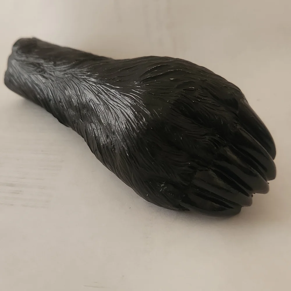 RESIN AND METAL BEAR PAW BOTTLE OPENER.